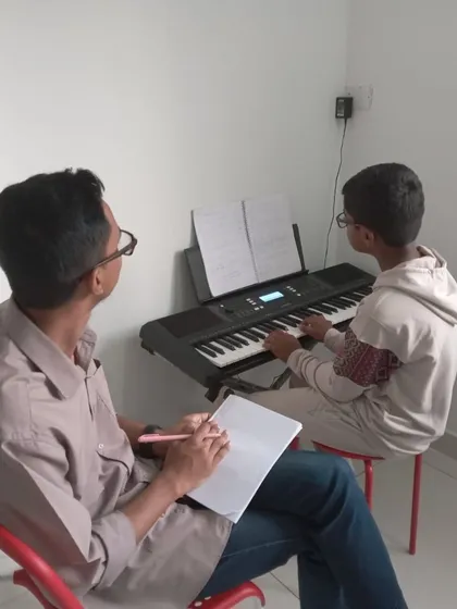 A student and teacher working together at the keyboard. This partnership is essential for musical growth.