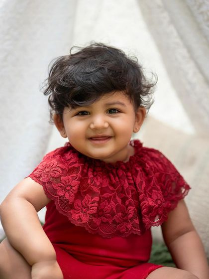 A beautiful close-up portrait from the teepee session. Her bright red outfit looks stunning against the green grass.