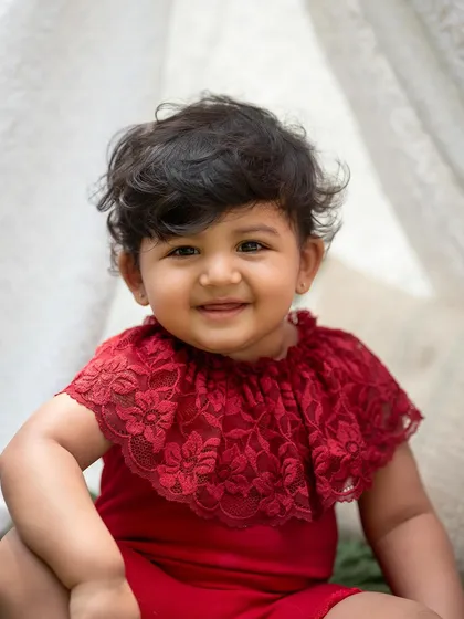 A beautiful close-up portrait from the teepee session. Her bright red outfit looks stunning against the green grass.