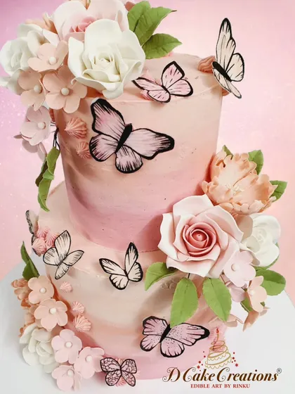 Another angle of the pink ombre cake, showcasing the arrangement of sugar flowers and butterflies that seem to float around the tiers.