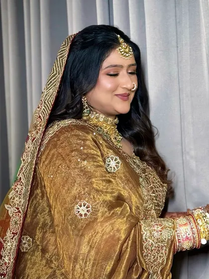A side profile shot that captures the soft glow of her makeup and the elegant fall of her dupatta.