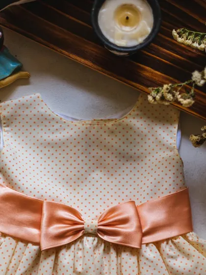 Another look at this lovely peach polka dot dress. The satin bow is the perfect finishing touch, adding a bit of sheen and structure to the soft cotton fabric.