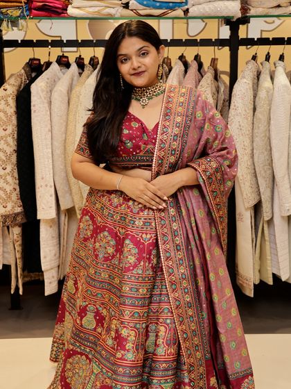 The details on this pink lehenga are stunning. The printed skirt and blouse are paired with a dupatta that has a contrasting border, adding another layer of design to the outfit.