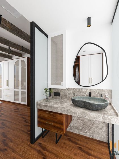 The open-plan bathroom vanity, featuring a stone sink on a marble countertop, seamlessly integrated with the bedroom space.