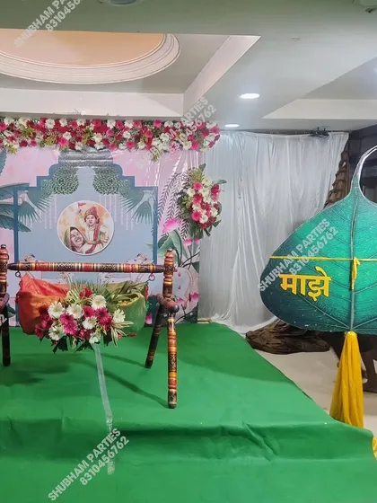 A beautiful naming ceremony (Naamkaran) stage with a traditional wooden cradle (jhula) decorated with flowers.
