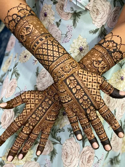 A full-coverage traditional mehandi design, showcasing intricate jaal (net) patterns, delicate floral work, and bold, clean lines. This style is perfect for anyone who loves a rich, detailed henna look.