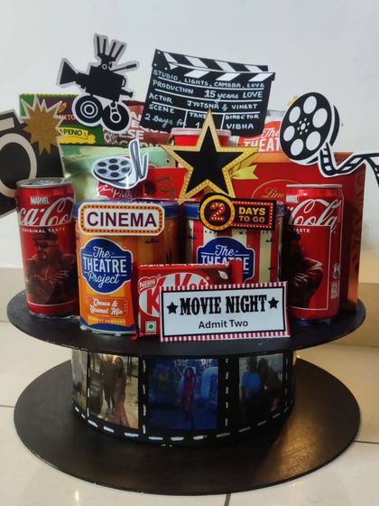 Lights, camera, action! This Bollywood-themed hamper is perfect for a movie lover. It's designed to look like a film reel and is filled with movie night essentials like popcorn, Coca-Cola, and KitKats.