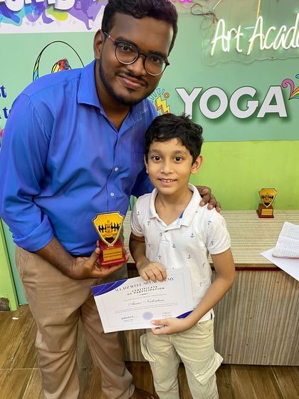 A smiling participant from our chess tournament, proudly holding his award. These events build sportsmanship and confidence.