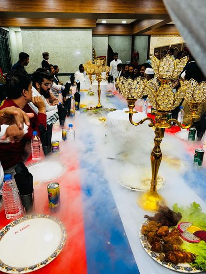 The smoke gently parts to reveal the feast. This shot captures the golden candelabras and beautifully plated food on the main table, creating an image of royal indulgence.