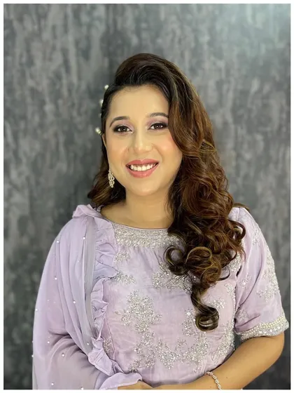 Charming in lavender and pearls. This look for a family event features soft purple tones on the eyes, glowing skin, and a side-swept hairstyle with pearl accessories.
