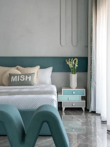 A detail of the kids' bedroom, focusing on the custom "MISH" pillow and the layered bedding. The soft textures and personalized touches make the space feel cozy and special.