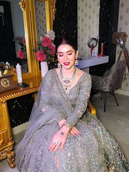 A beautiful client looking radiant in a grey lehenga with a bold red lip.