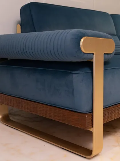 A close-up of the custom sofa's arm, highlighting the elegant T-shaped brass handle and plush upholstery.