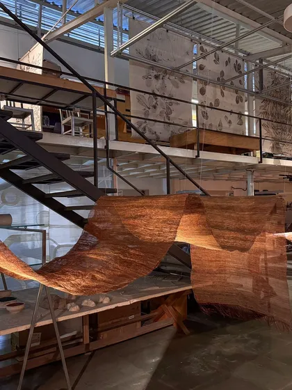 A view of the 'Cu+Fibers' installation from our studio's mezzanine level. The flowing, semi-transparent woven sculpture interacts with the industrial architecture of the space.