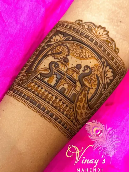 This arm band features two peacocks flanking a palace view, creating a symmetrical and regal design that is both beautiful and symbolic.