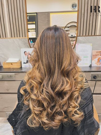 A fresh hair colour can change your whole vibe. Here, we've styled a beautiful balayage into soft, cascading curls, showing off the seamless blend of tones and giving the hair a rich, dynamic look.
