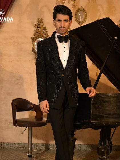 This shot captures the full regal presence of the black sequined tuxedo, perfect for a groom's reception.