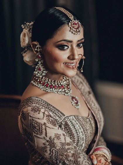 A close up portrait of the same beautiful bride, highlighting her flawless makeup, stunning jewelry, and happy expression.