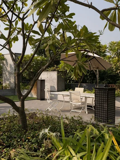 Strategic green spaces are key to our designs. This shaded outdoor area provides a cool, comfortable spot for relaxation, demonstrating how landscape integration can create more livable spaces.