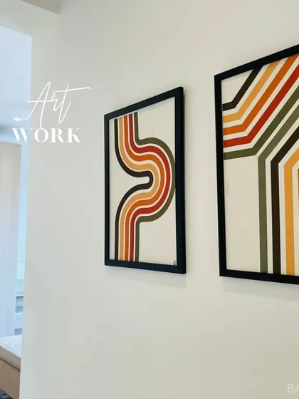 Finding balance in asymmetry. We selected and placed this two-piece retro-style artwork to add a splash of color and graphic interest to a minimalist wall.