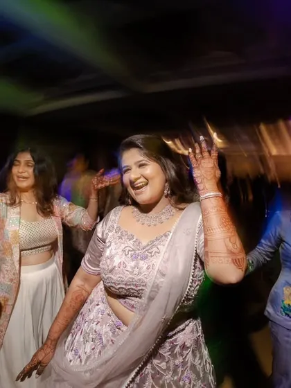 The bride and her friends dancing their hearts out. The colorful lights and motion blur convey the excitement of the party.