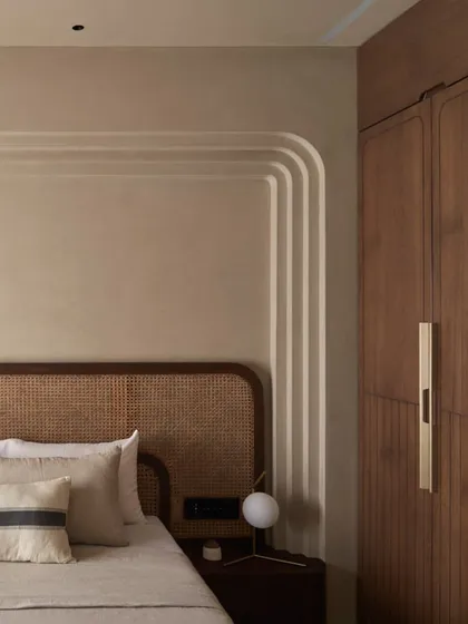 The combination of the grooved wooden wardrobe and the arched wall details creates a room rich in texture and architectural interest. Every element is designed to contribute to a sense of peace.