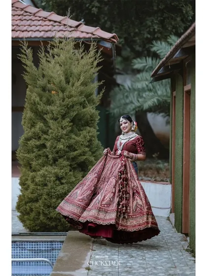 A beautiful shot of the bride twirling in her magnificent red lehenga, showcasing the intricate details and grandness of her wedding outfit.