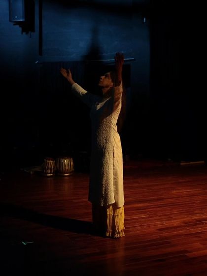 A dancer reaches up during the tech run for "Immersed."