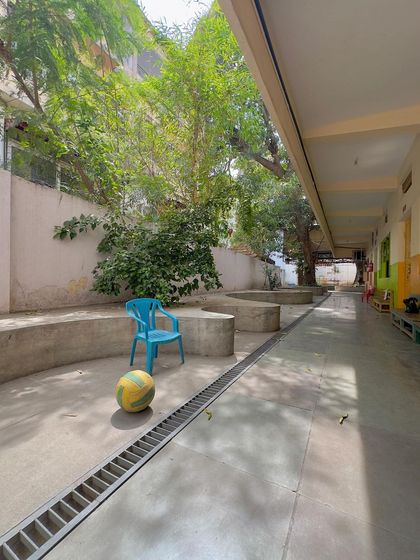 A simple blue chair and a ball in the school courtyard, a poignant image of the life and play that our spaces are designed to hold.