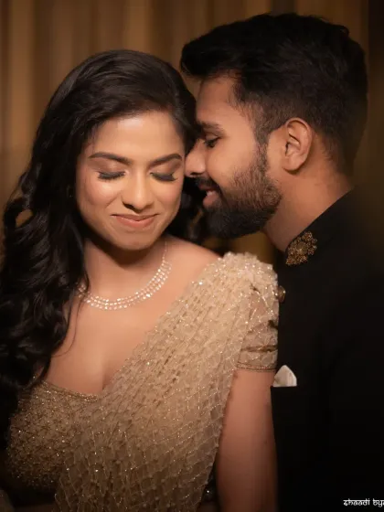 A quiet moment of intimacy during a reception photoshoot. The soft lighting and close crop focus entirely on the couple's connection.