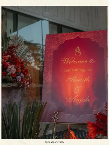 A personalized welcome sign for the "Jashn-e-Sagai," featuring the couple's monogram and a rich, warm color palette that sets the tone for the event.