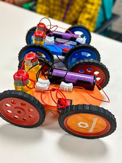 A lineup of completed electric cars from one of our workshops. Each child customizes their build, making every car unique.