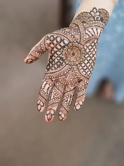 A beautiful bridal design with a central floral mandala and intricate gridwork filling the rest of the hand.
