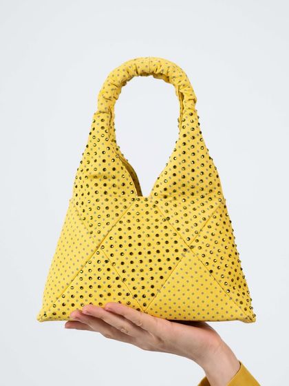 A close-up view of my butter yellow polka dot bag. You can see the detailed handwork of the glass stones and the soft, scrunchie-style handle that makes it comfortable to carry.