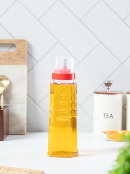 A clean kitchen shot of an Oliveware oil dispenser, styled in a bright, modern kitchen setting to show its everyday utility.