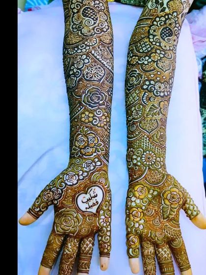 A beautiful bridal design with the names 'Shuaib' and 'Fazila' written inside a heart.
