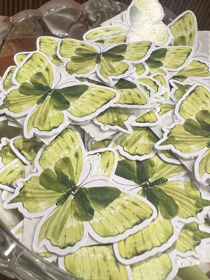 A bowl of custom butterfly cutouts, part of the "Baby in Bloom" printable set for a baby shower.