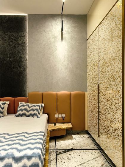 A detail shot highlighting the textures of the wall, headboard, and wardrobe, showcasing a masterful blend of materials.