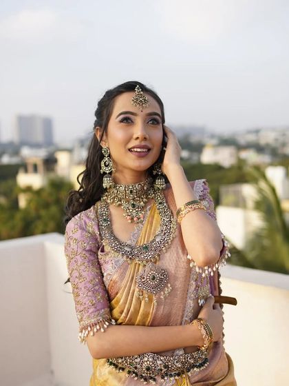 A beautiful, dreamy shot of the model looking up, highlighting the maang tikka and the soft waves in her hair.