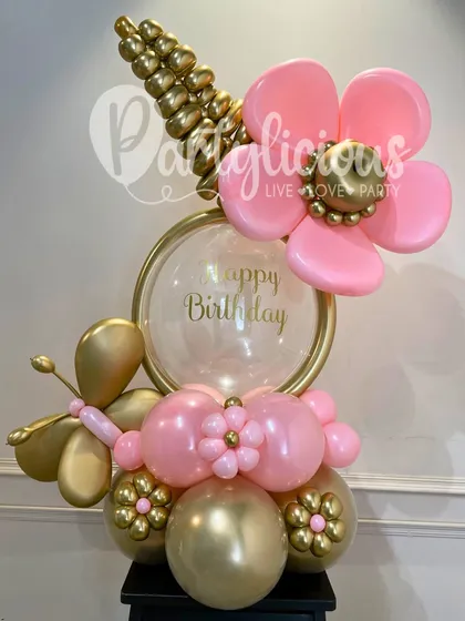 A close-up of one of our artistic birthday bouquets. The combination of a pink balloon flower, a golden butterfly, and a personalized bubble balloon shows the level of detail and care in our work.