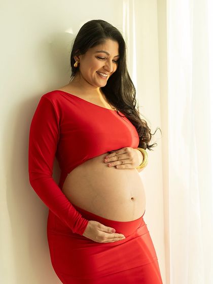 A radiant smile and a beautiful bare bump. This portrait, taken in soft natural light, celebrates the beauty of the pregnant form in a simple and honest way.