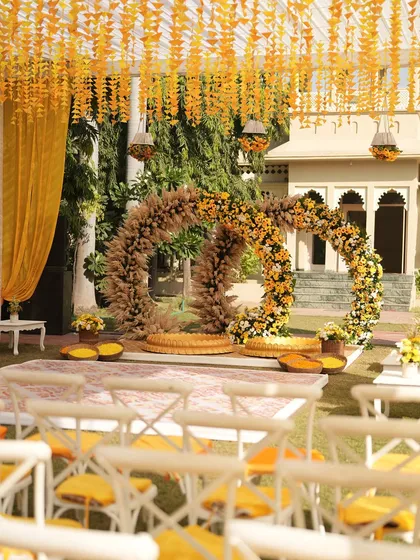 A wider view of the sunflower-themed Haldi setup, showing the seating arrangement and the beautiful circular backdrop. The entire space is designed to feel bright and joyful.