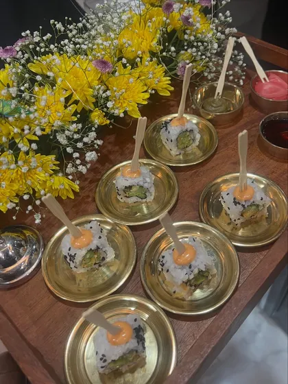 Presentation is just as important as taste. Here, we've served our fresh avocado sushi on elegant brass plates, garnished with a dollop of spicy mayo. These little details are what make our gourmet catering service feel special.