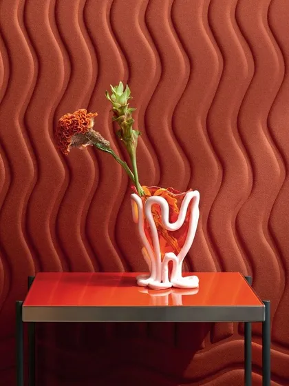 This video showcases a 3D wallcovering with a wavy, undulating pattern in a rich terracotta color. The design adds a soft, sculptural quality to the wall, creating a modern and visually interesting backdrop.