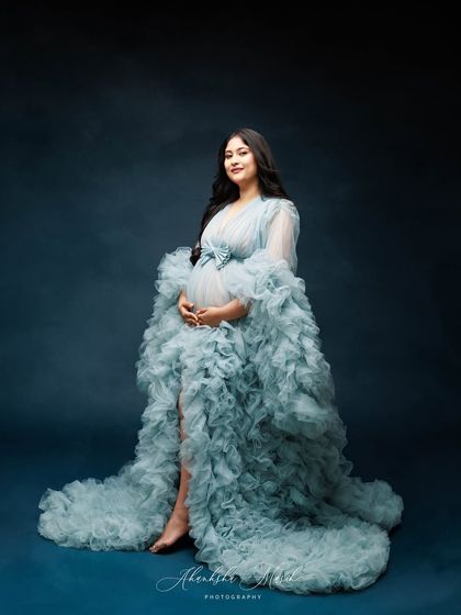 A full-length view of the blue ruffled gown against a matching backdrop, creating a cohesive and majestic portrait.