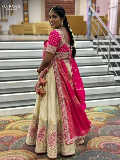 A full view of the elegant pink and cream lehenga. The combination of colors and the traditional design make it a graceful choice for any wedding function.