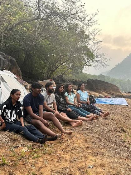 Relaxing by the riverside at our campsite, watching the sunset after a day of trekking.