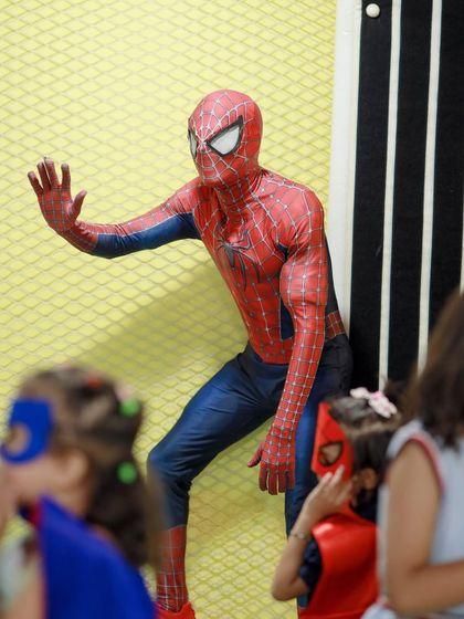 Spider-Man makes a surprise entrance, waving to his little fans who are all dressed up in their own hero masks and capes. It's these interactive moments that make our parties so magical.