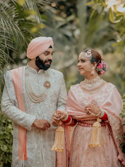 A candid, loving portrait of Simran and Sanjit, their pastel pink and white outfits perfectly suited for a daytime Anand Karaj.