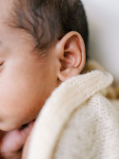 A close-up detail shot of a newborn's tiny ear, showcasing their delicate features.